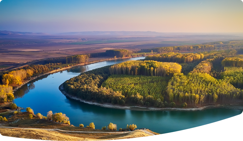 Sunrise over a large river meander.